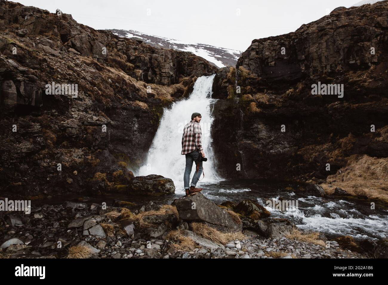 Anonymous tourist with camera against waterfall Stock Photo