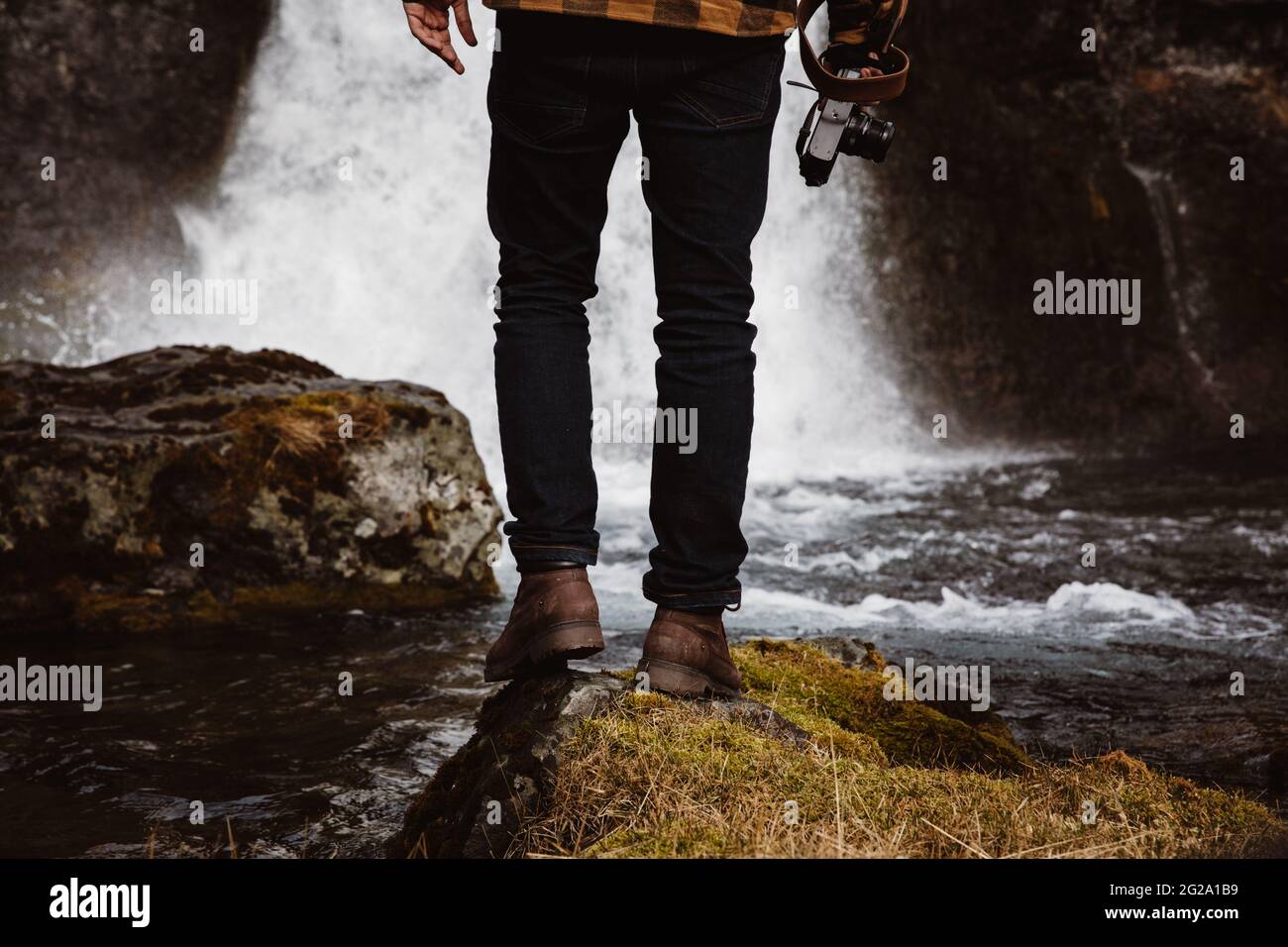 Anonymous tourist with camera against waterfall Stock Photo