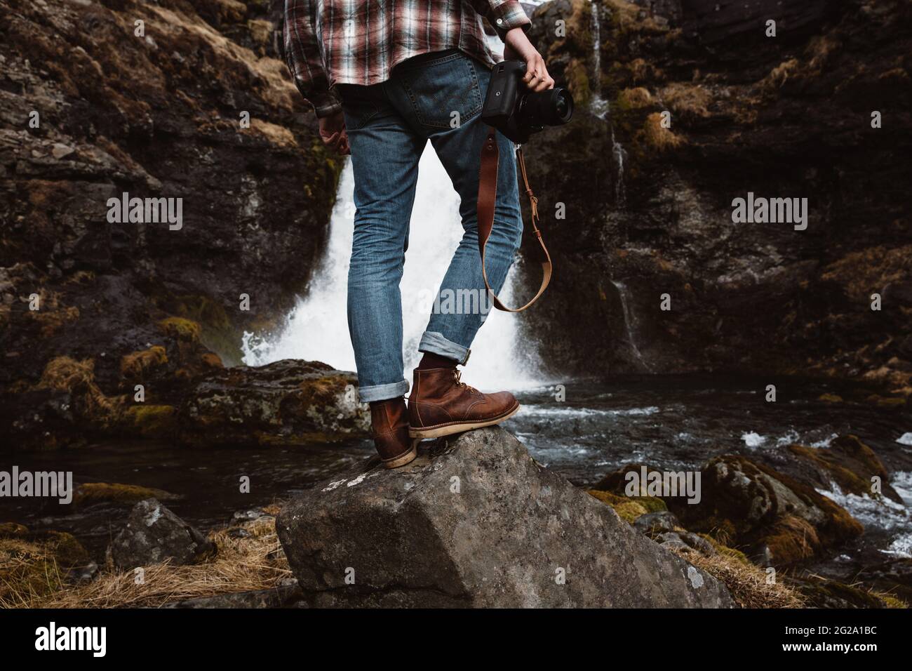 Anonymous tourist with camera against waterfall Stock Photo