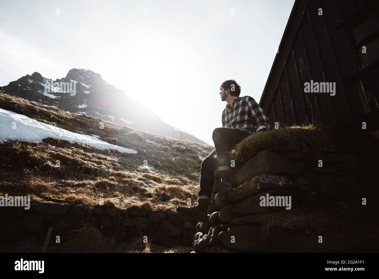 Young man looking at mountain and sun Stock Photo