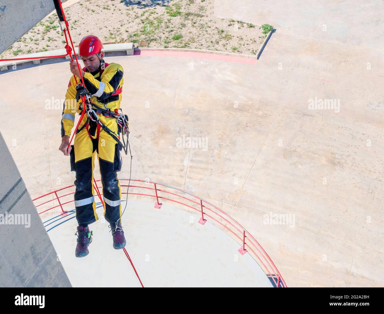 Professional fireman climber in uniform hanging on ropes while training ...