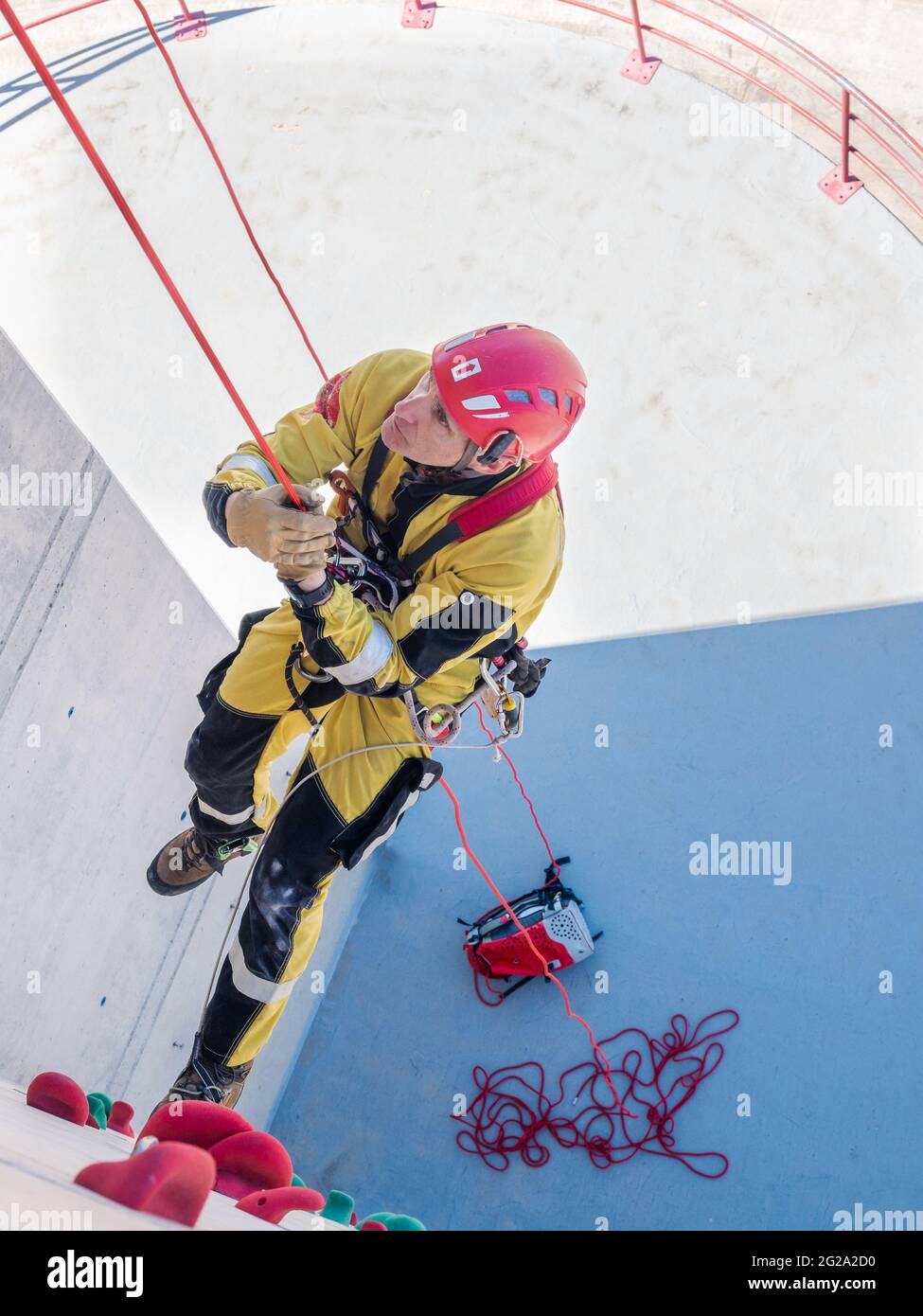 Professional fireman climber in uniform hanging on ropes while training ...