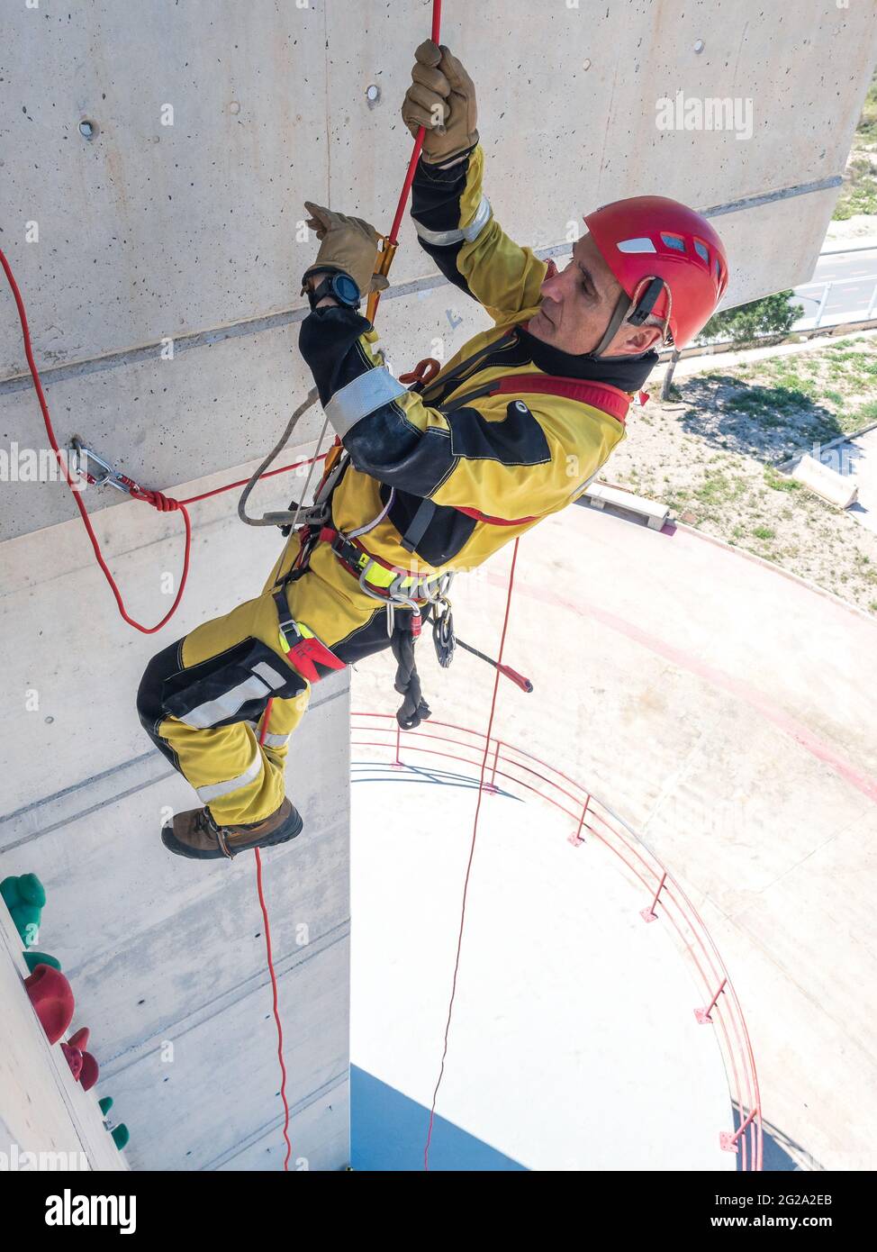 Professional fireman climber in uniform hanging on ropes while training ...