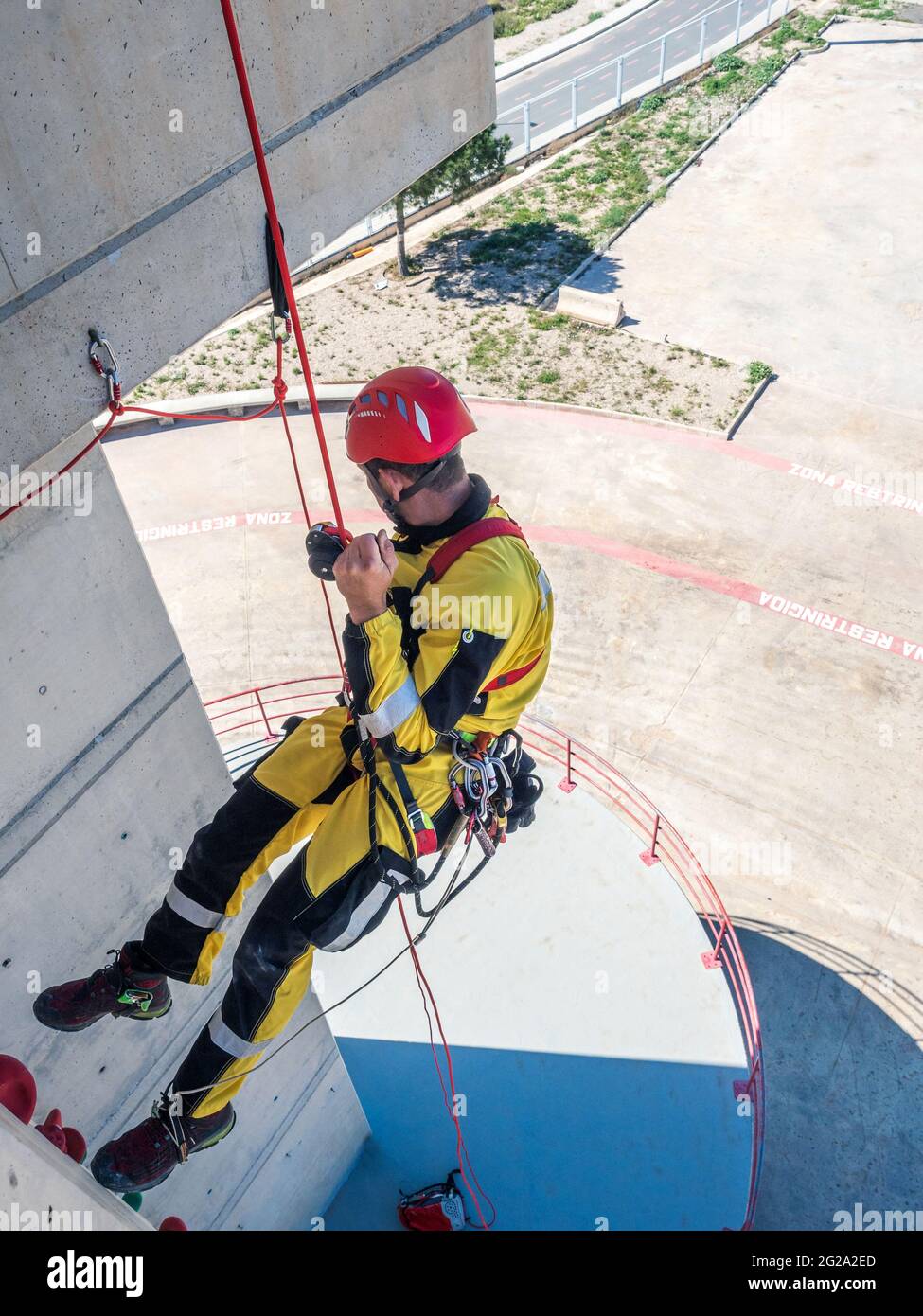 Professional fireman climber in uniform hanging on ropes while training