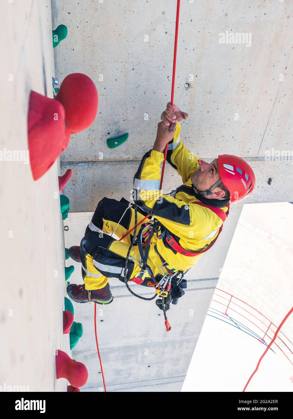 Professional fireman climber in uniform hanging on ropes while training