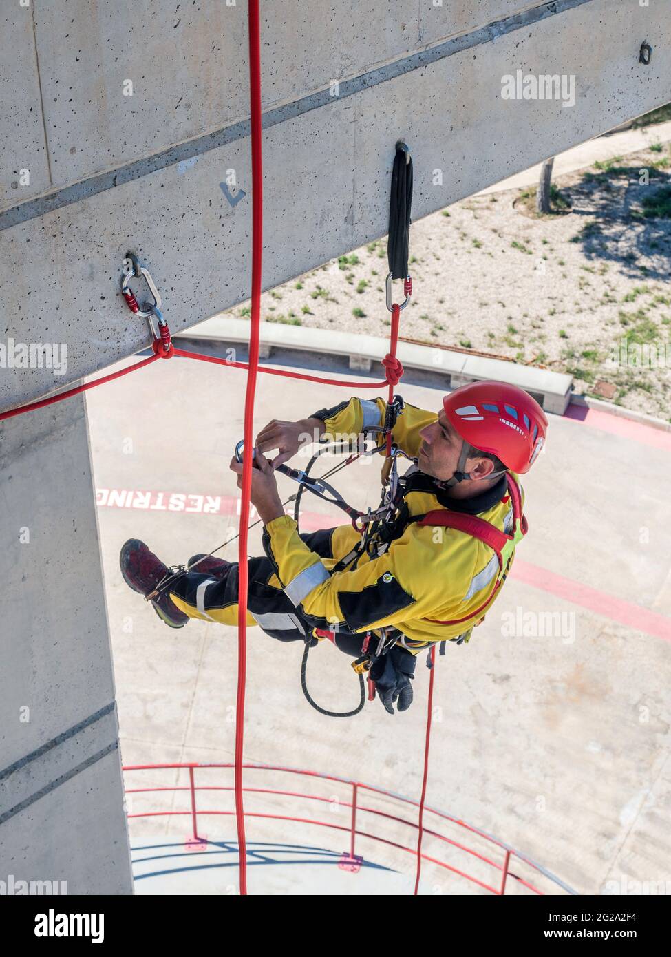 Professional fireman climber in uniform hanging on ropes while training