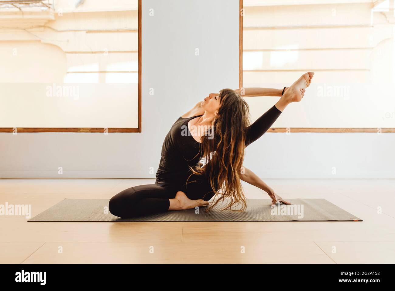 Young pretty Woman in sportswear practicing yoga asana on floor in ...