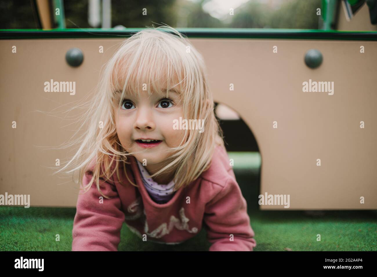 Happy Little girl playing at a playground and looking away Stock Photo ...