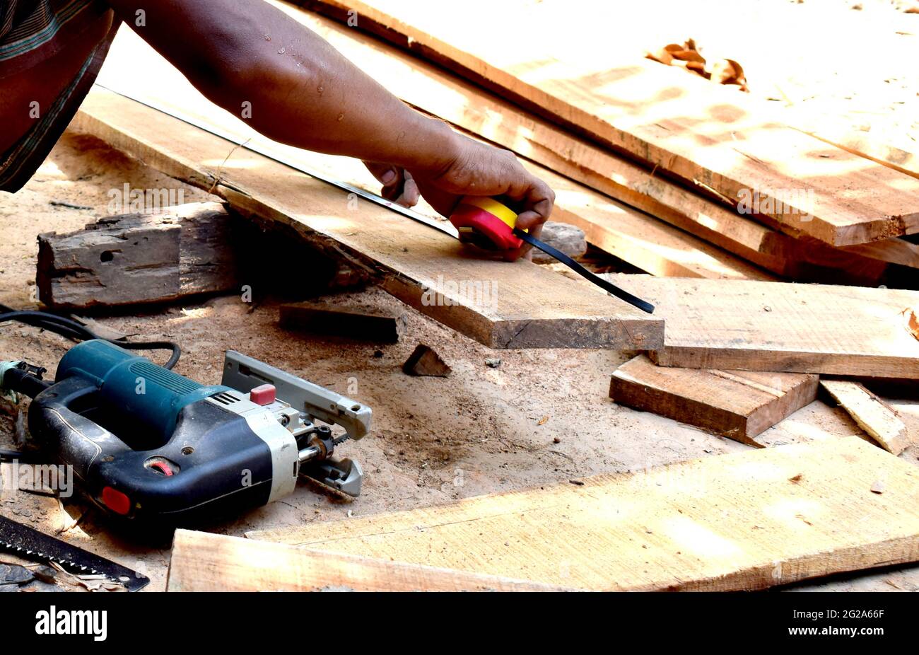 carpenter ccaucasian man using measuring tape looking wood size at workspace. craftsman profession in wood factory. Stock Photo