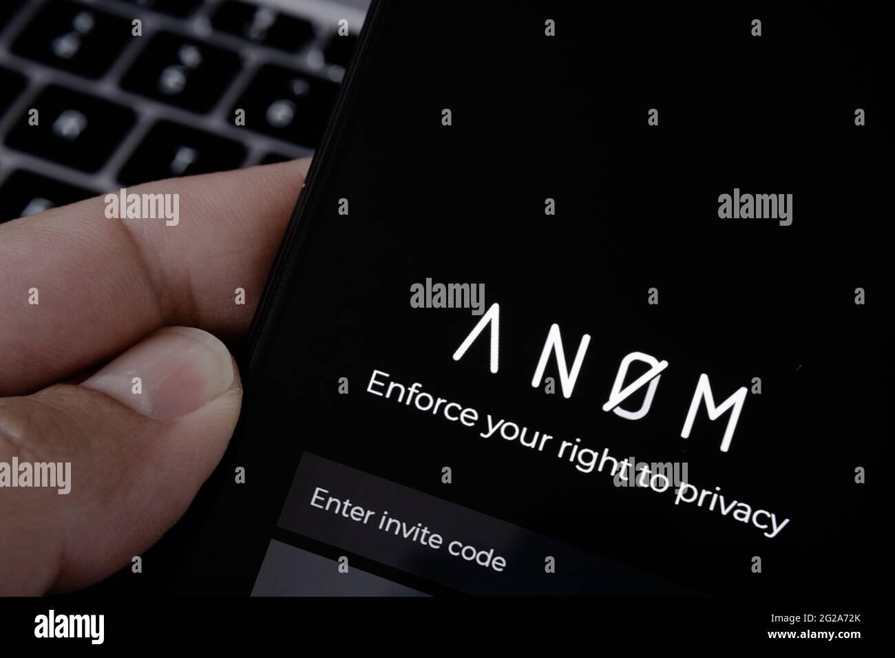 ANOM app logo seen on the smartphone and laptop on blurred background. Encrypted messaging app used in global crime networks. Concept. Stafford, Unite Stock Photo