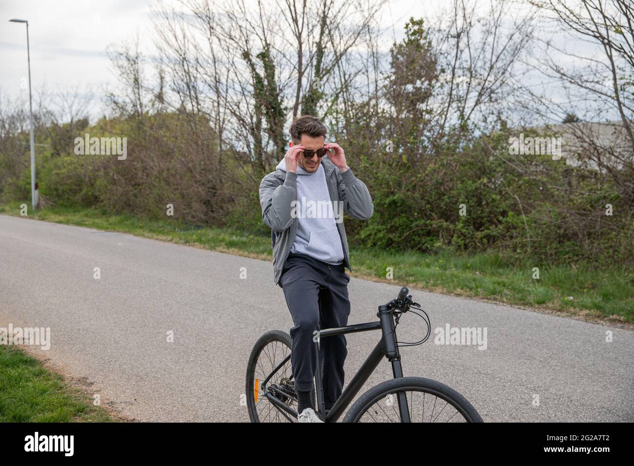 A young boy sitting on his bicycle wearing sunglasses, is ready to go for a ride. Transportation and outdoor life concept Stock Photo