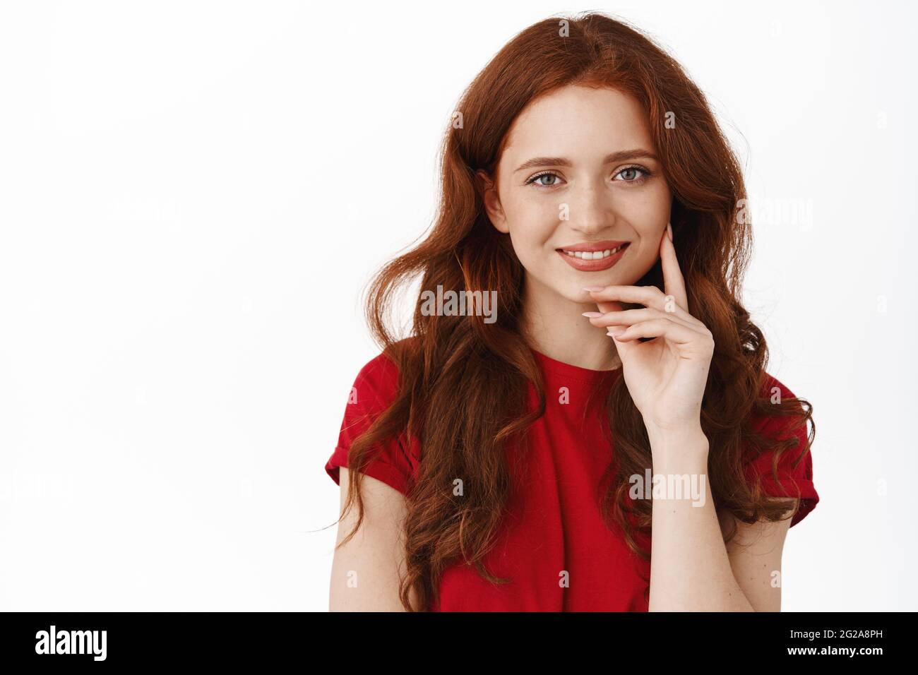 Close up portrait of authentic redhead woman, smiling and touching natural  no make up face, gazing happy and cute at camera, standing in red t-shirt  Stock Photo - Alamy