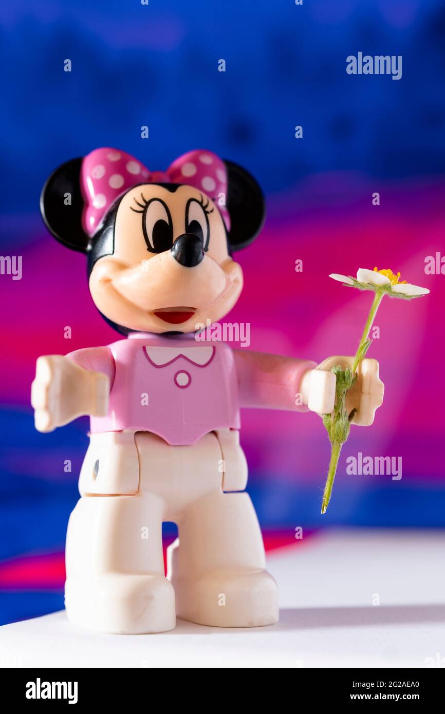 New York, USA - May 25, 2021: A close up shot of a miniature famous Disney character Minnie Mouse Disney character holding a flower. Stock Photo