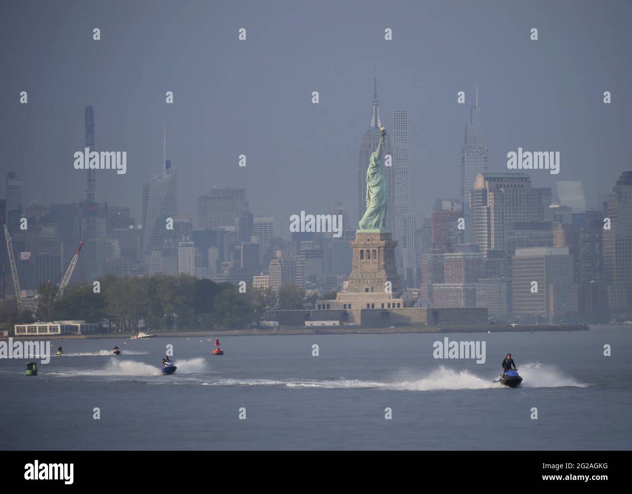 Bayonne, United States. 09th June, 2021. People ride jet skis in the Hudson River with a view of