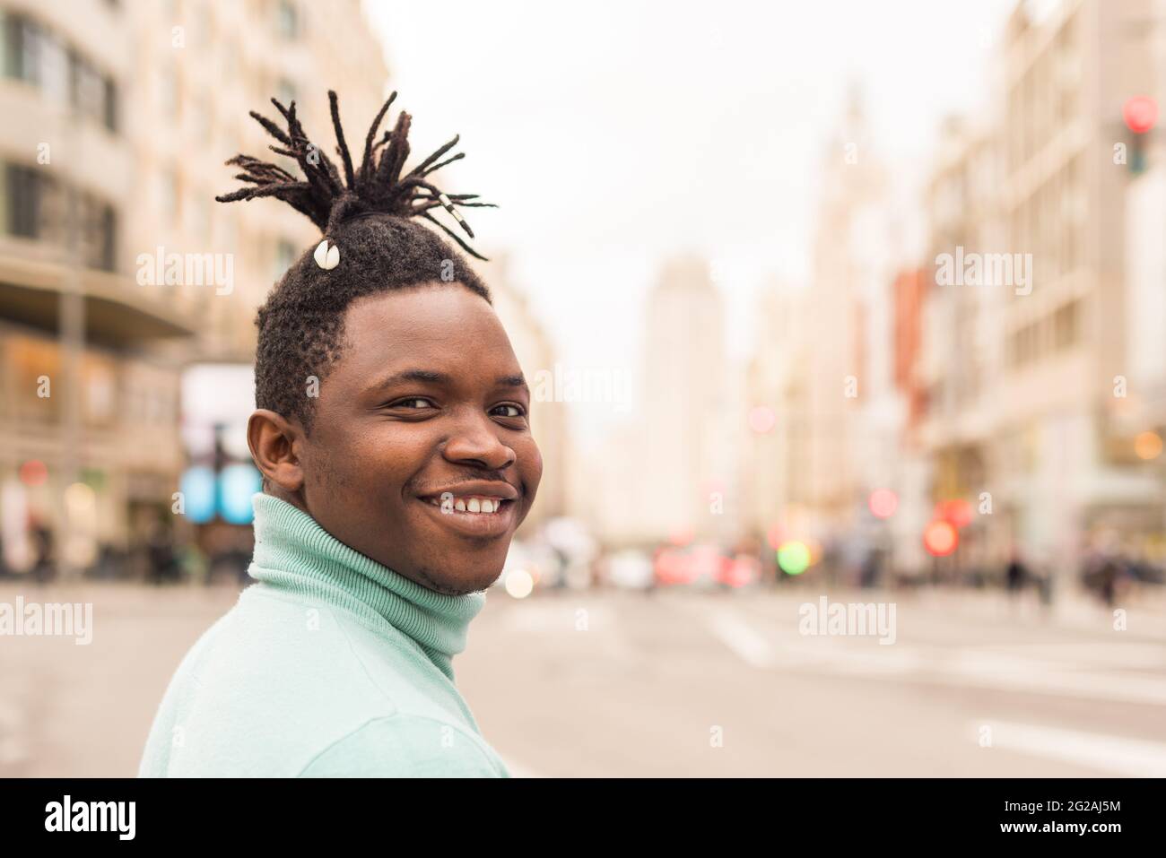 Young black man in the middle of the city, smiling. Stock Photo