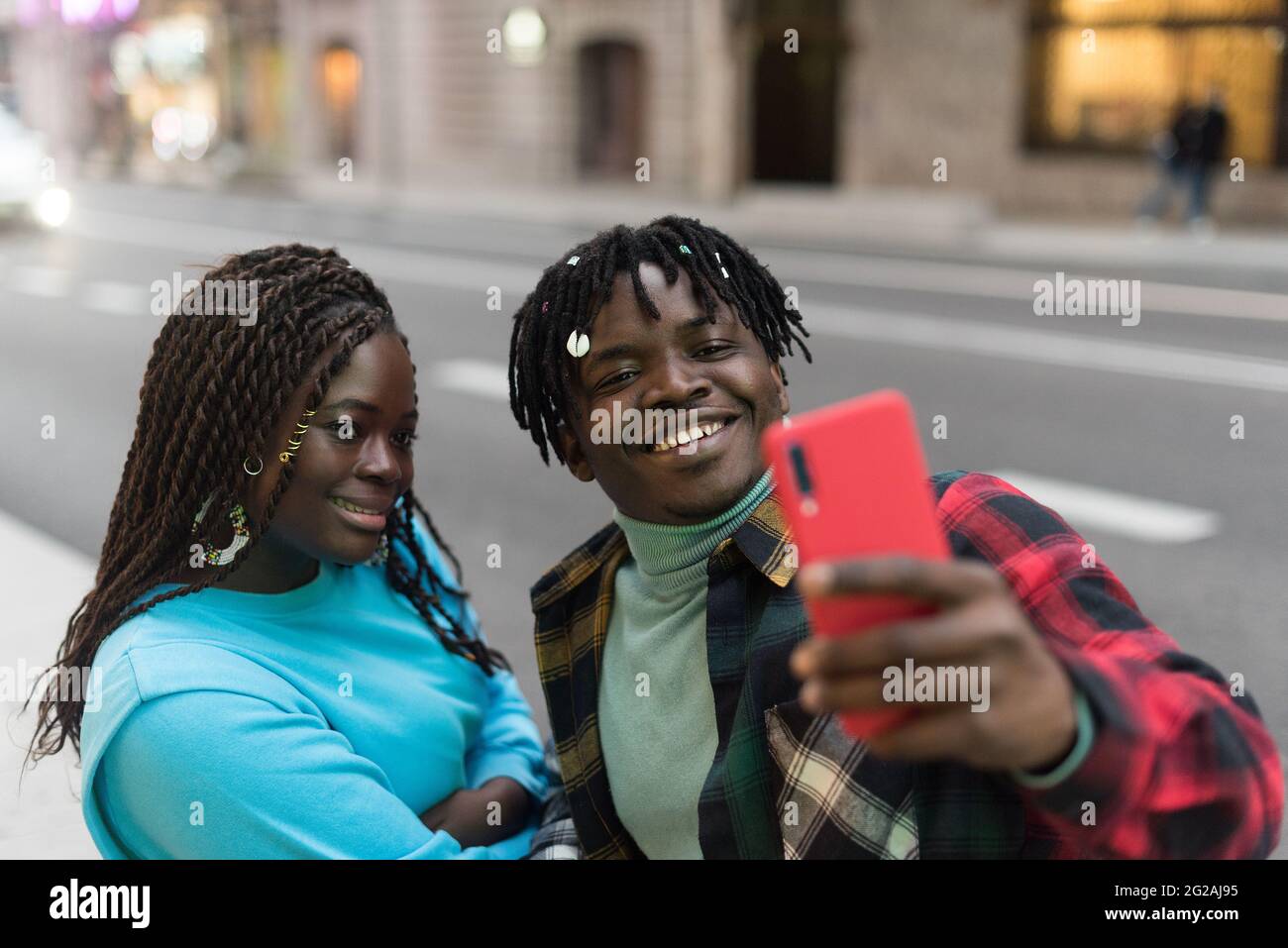 Smiling black couple taking a selfie on the street. Stock Photo