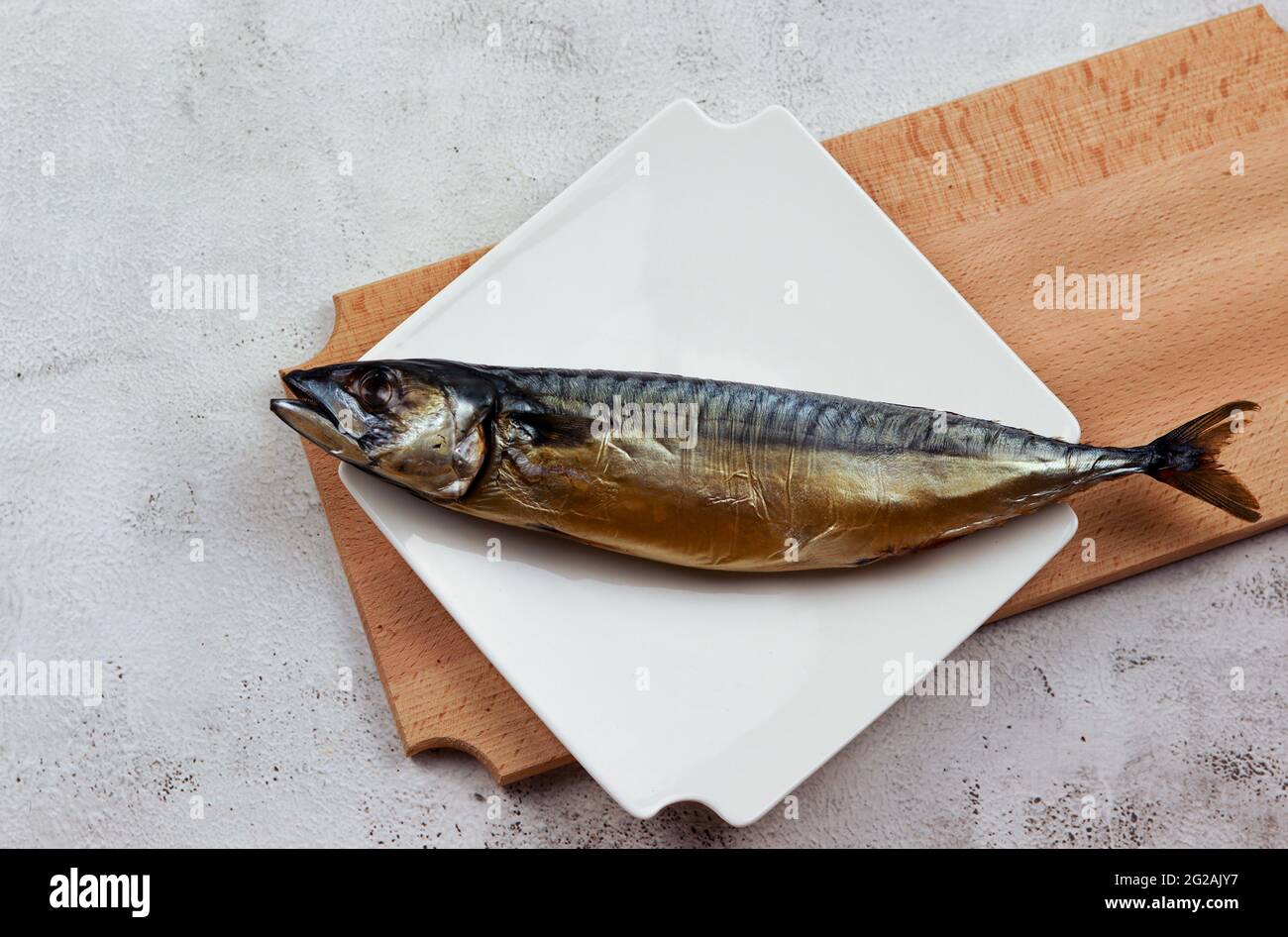 Smoked mackerel on a white rectangular plate on a light gray background. Top view, flat lay Stock Photo