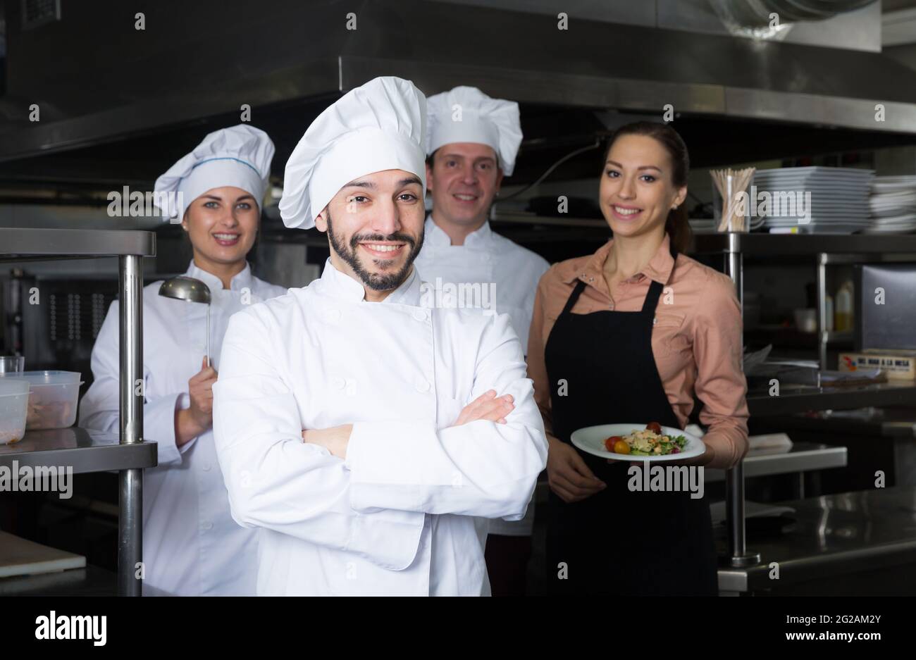 Chef in kitchen with staff Stock Photo