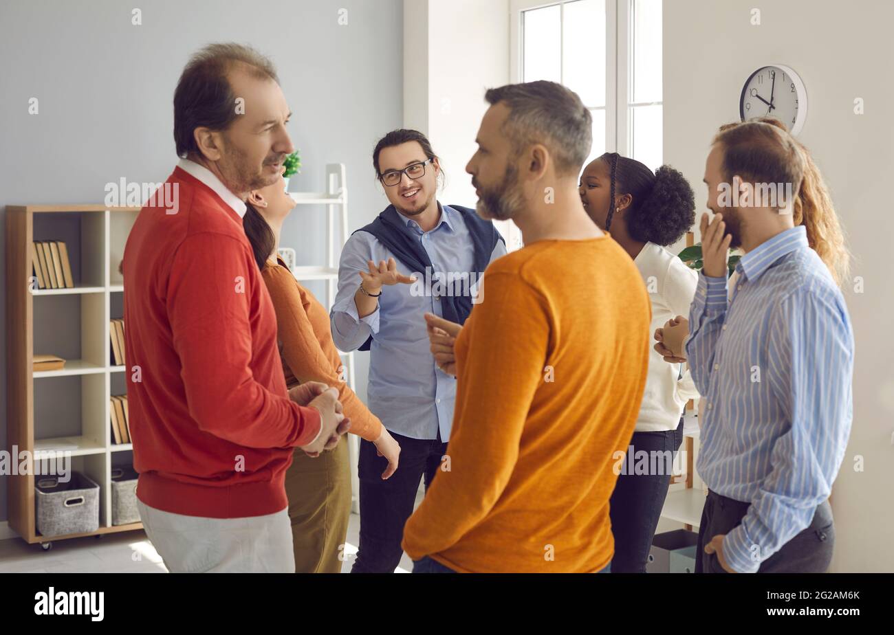 Groups of different people standing randomly and talking on business meeting Stock Photo