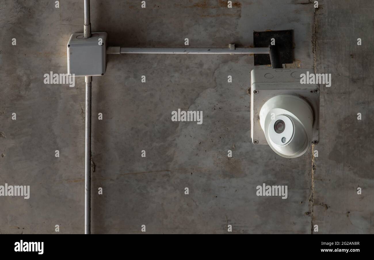 Modern surveillance cameras for ceiling mounted on concrete wall in the