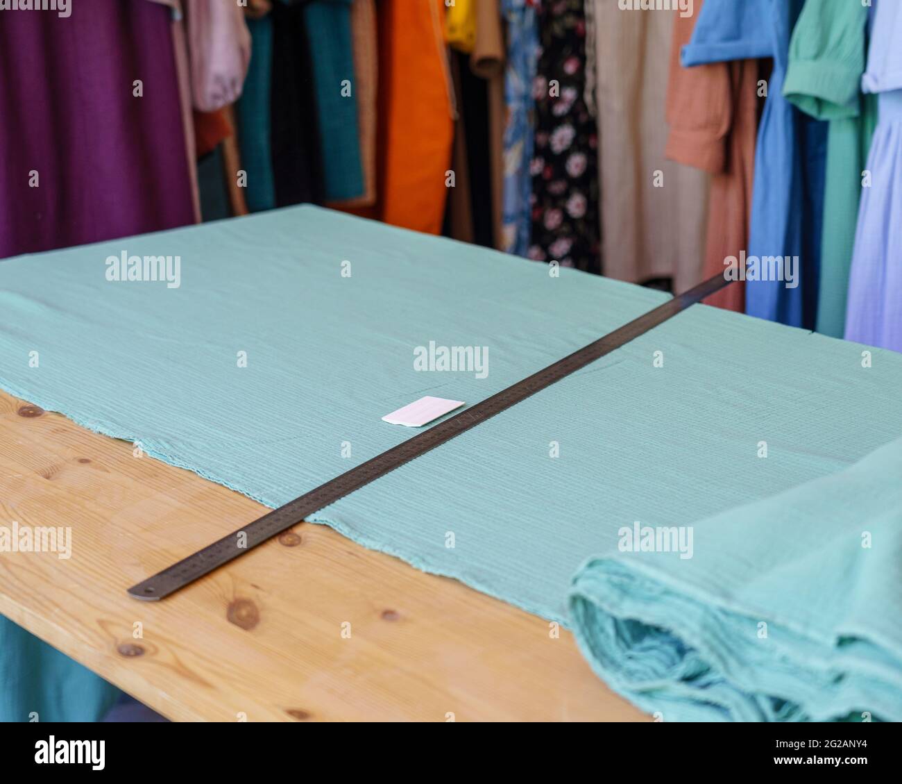 Workplace of seamstress or tailor with cloth square, metal ruler and piece of soap in atelier Stock Photo