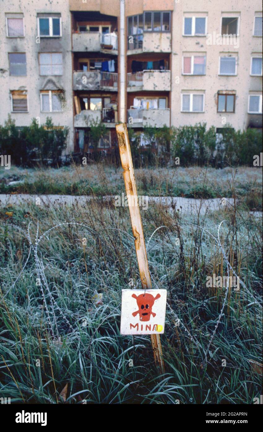 Sarajevo, Bosnia and Herzegovina. March 1997. Warning sign and razor wire protect a mined area in the city. Mina or Mines warning. The Bosnian War, ethnically rooted war in Bosnia and Herzegovina that took place from 1992 to 1995 in Former Yugoslavia. Stock Photo