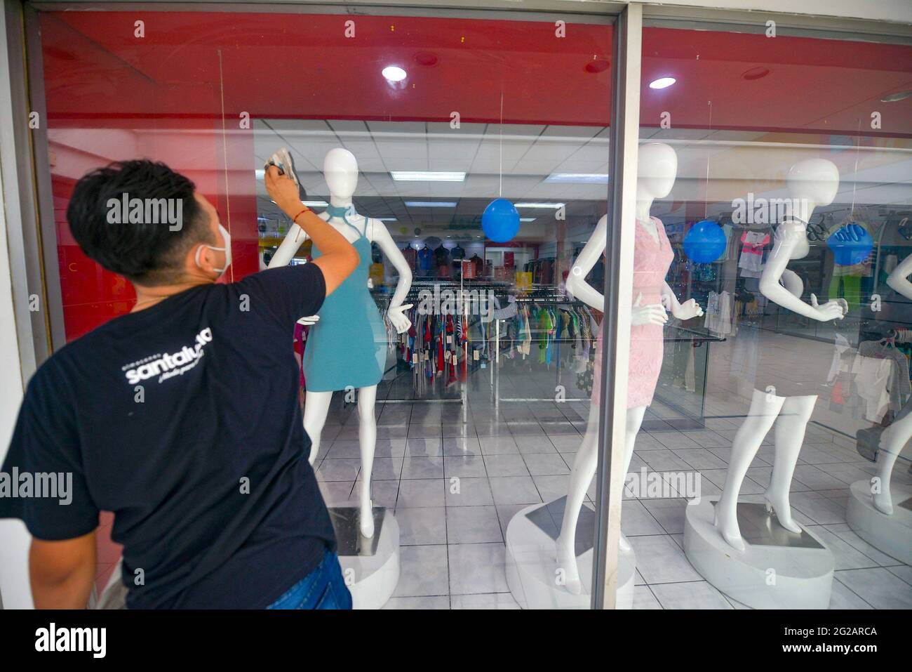 San Salvador, El Salvador. 09th June, 2021. A man cleans the windows of a clothing store at a mall.El Salvador's Congress approved Bitcoin as a legal tender, meanwhile, President Nayib Bukele announced the country will move into creating Bitcoin mining hubs with the country's geothermal infrastructure. (Photo by Camilo Freedman/SOPA Images/Sipa USA) Credit: Sipa USA/Alamy Live News Stock Photo