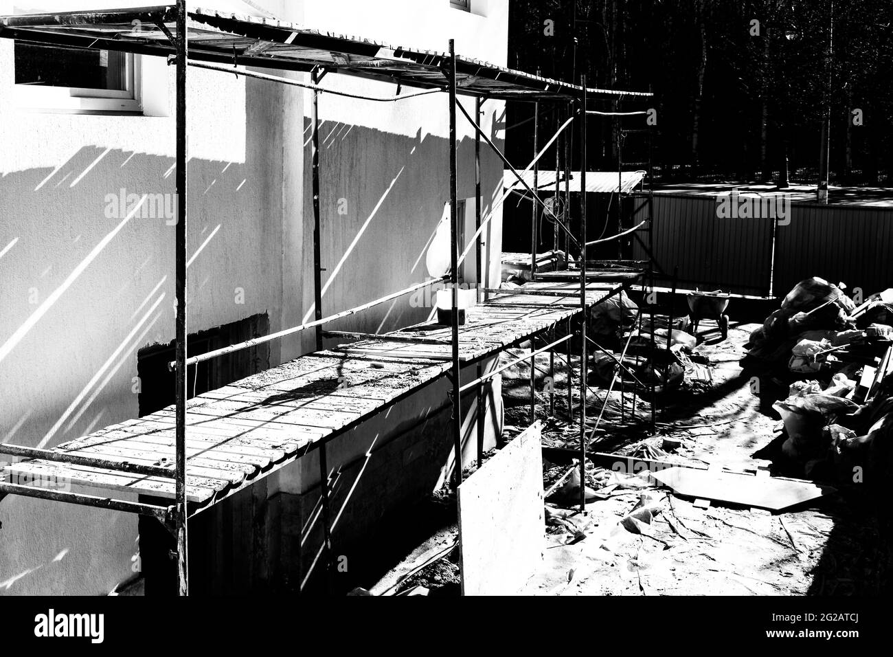 Black and white concept of building renovation with scaffolding and construction debris in the courtyard Stock Photo