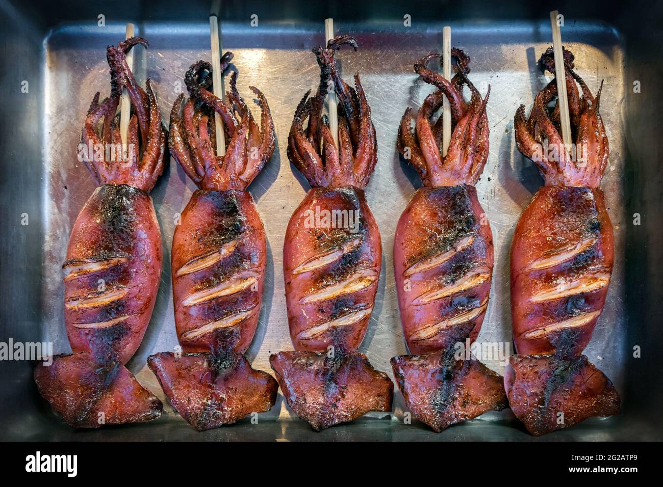Japanese street food on Enoshima Island, roasted squid on a stick Stock