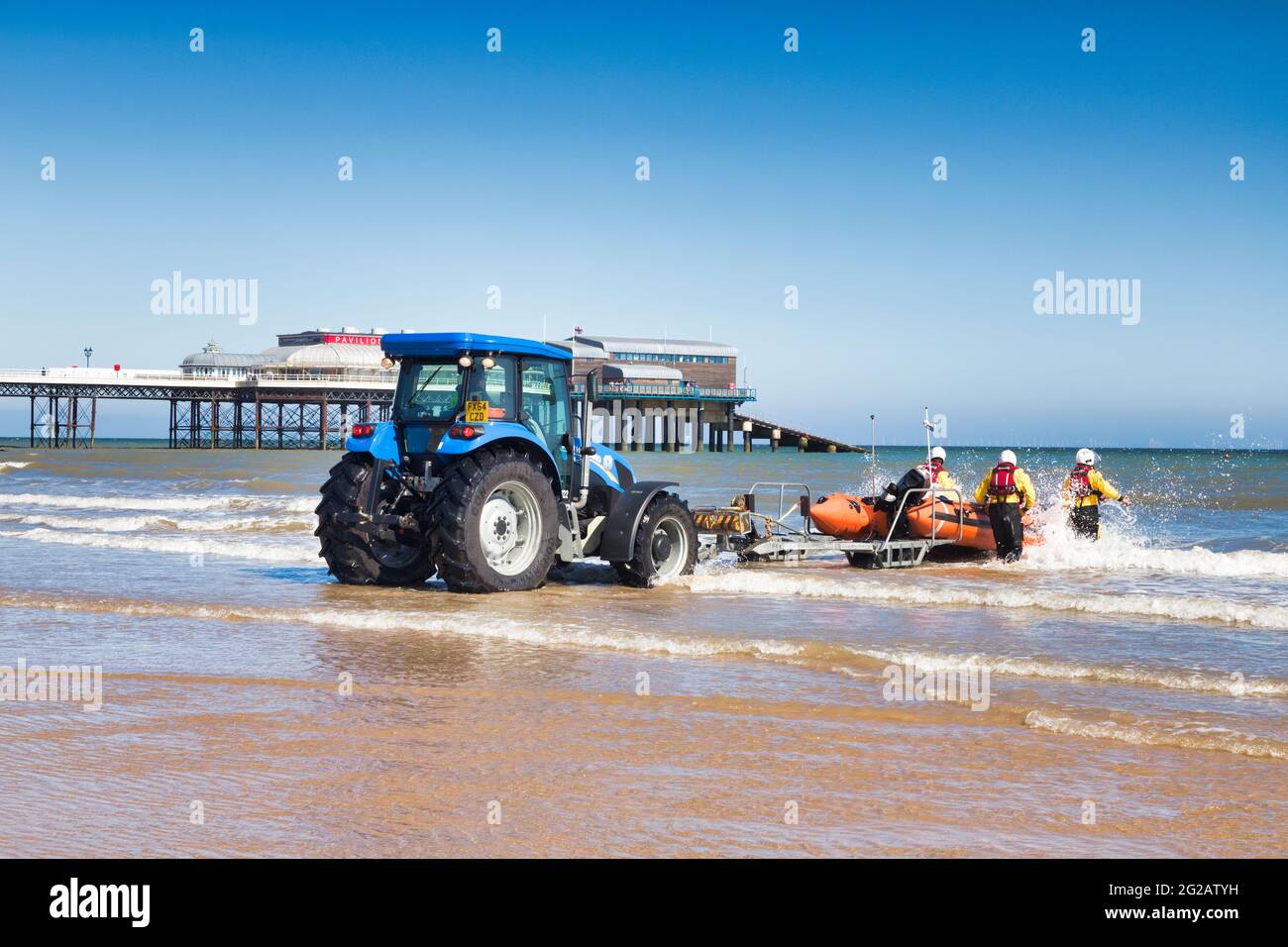 30 June 2019: Cromer, Norfolk, UK -  RNLI inshore lifeboat being pushed out into sea during training exercise. Stock Photo
