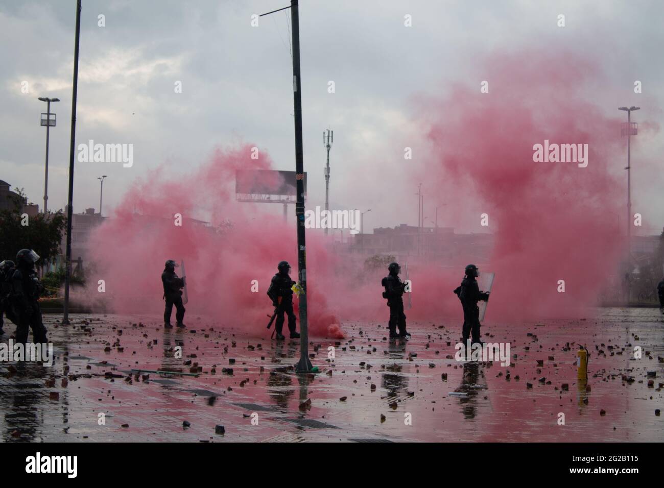 Bogota, Colombia.  9th June 2021. A group of Colombia's riot police (ESMAD) officers behind a red smoke tear gas grenade as demonstrations turned into clashes in southern Bogota at Portal de las Americas so-called by demonstrators 'Portal Resistencia' during the start of the 6th week of anti-government protests against President Ivan Duque's tax and health reform, equality in the country and police brutality. On June 9, 2021 in Bogota, Colombia Credit: Long Visual Press/Alamy Live News Stock Photo