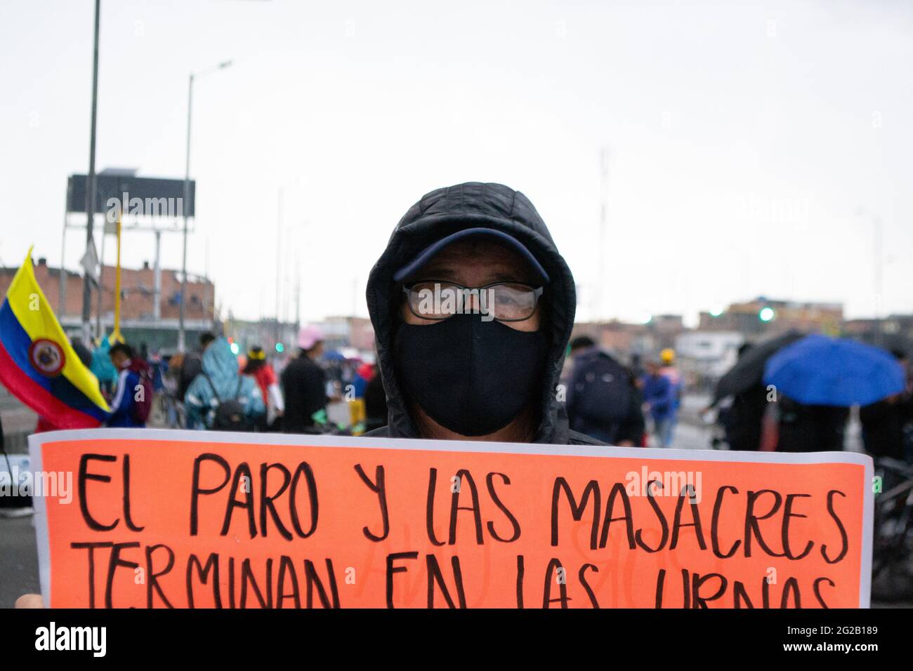 Bogota, Colombia.  9th June 2021. A demonstrator holds a sign that reads 'The Strike and the Massacres' as demonstrations turned into clashes in southern Bogota at Portal de las Americas so-called by demonstrators 'Portal Resistencia' during the start of the 6th week of anti-government protests against President Ivan Duque's tax and health reform, equality in the country and police brutality. On June 9, 2021 in Bogota, Colombia Credit: Long Visual Press/Alamy Live News Stock Photo