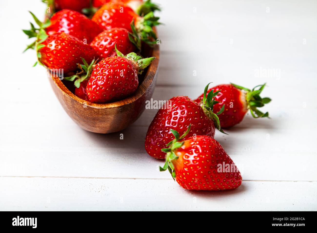 Ripe strawberries in a wooden bowl on a wooden background Stock Photo ...