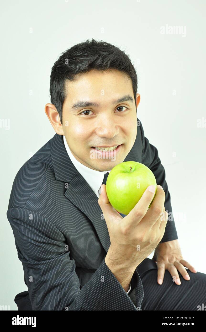 Businessman holding green apple Stock Photo - Alamy