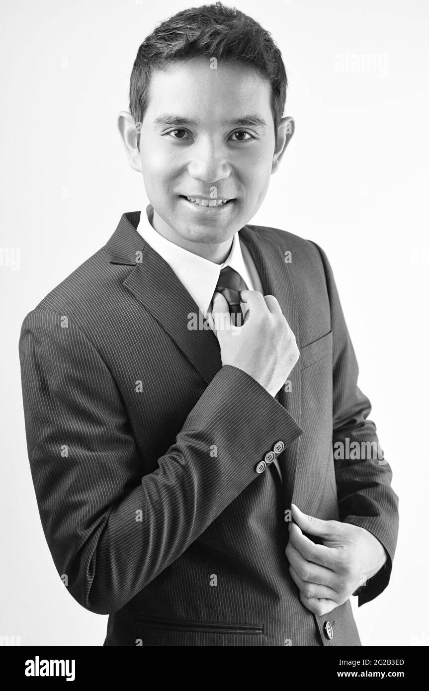 Smiling businessman holing necktie Stock Photo