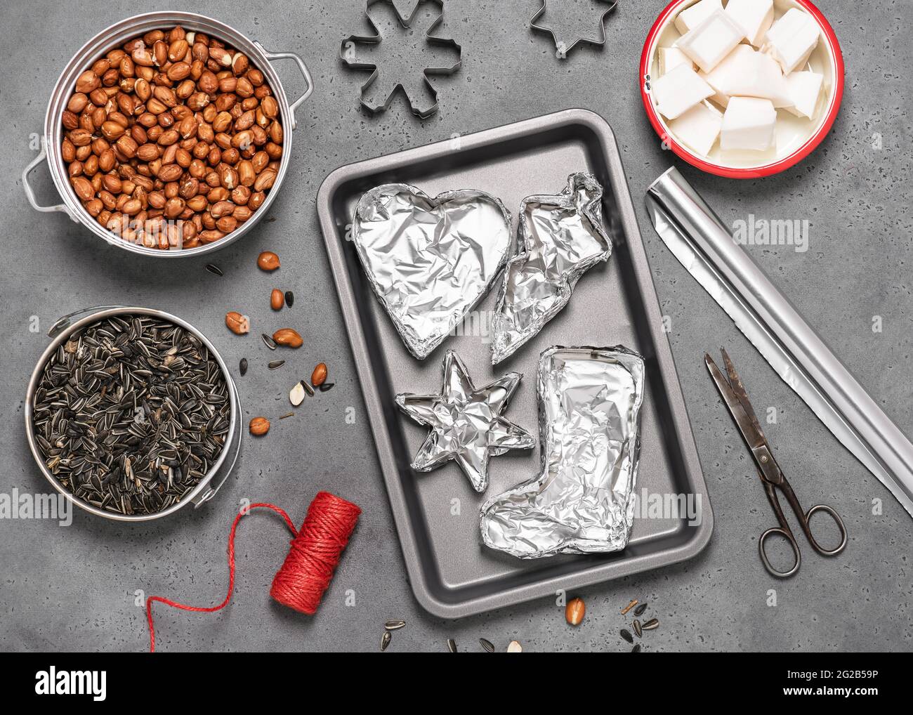 Making birdseeds cookies. All of cookie cutters wrapped with aluminum foil. Children education concept. Help people to animals. Top view. Stock Photo