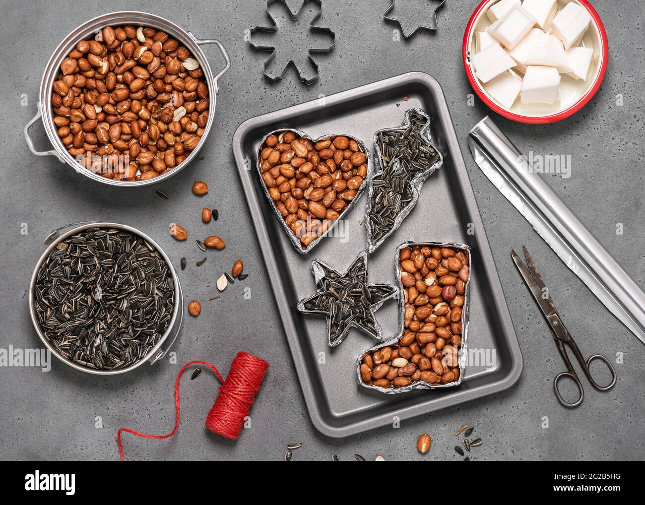 Making birdseeds cookies. All of cookie cutters filled with peanuts and sunflowers seeds. Children education concept. Help people to animals. Top view Stock Photo