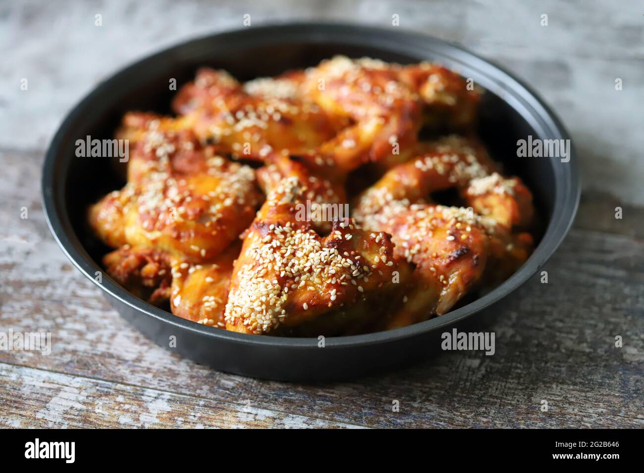 Baked chicken wings with sesame seeds in a skillet. Junk food