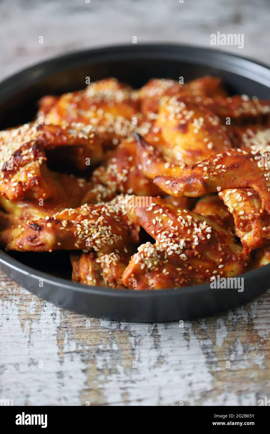 Baked chicken wings with sesame seeds in a skillet. Junk food