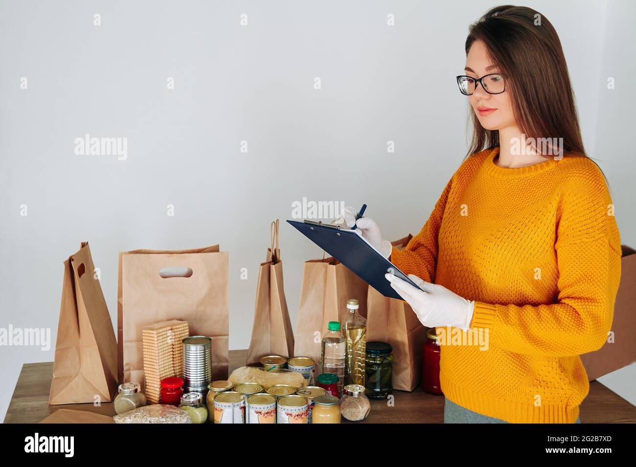 woman in medical gloves packing food for donation Stock Photo - Alamy