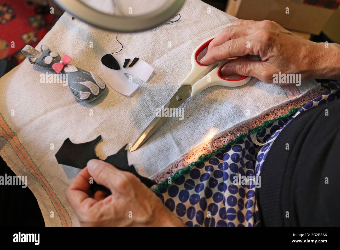 The woman is engaged in needlework. Additional income. Stock Photo