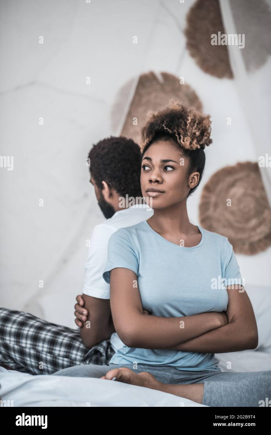African American woman sitting with her back to husband Stock Photo