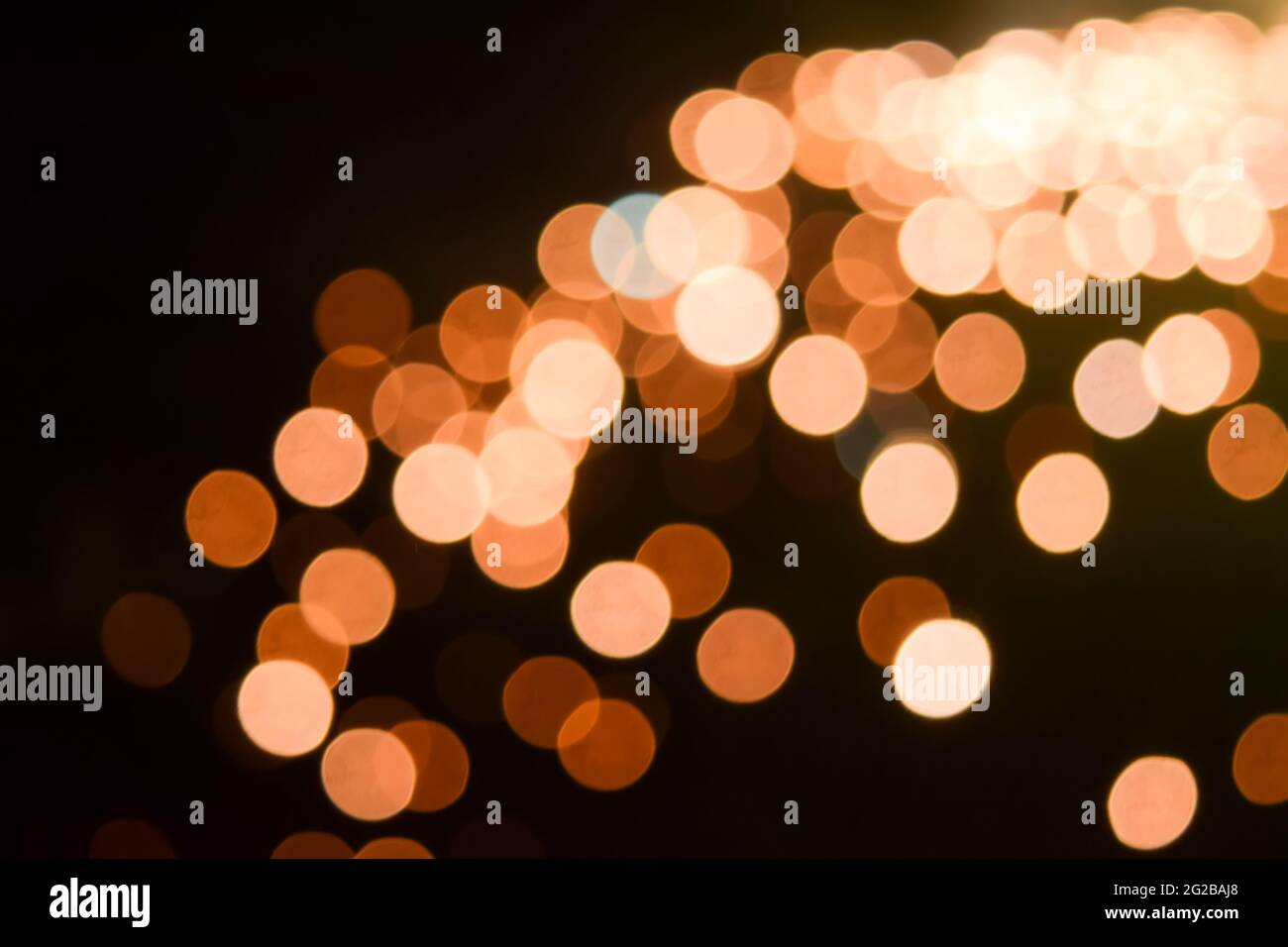 Abstract bokeh of light for background of Orange colored shades with black colored background. Stock Photo