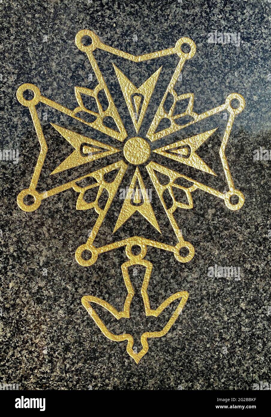 Huguenot cross on a grave in a Protestant cemetery. Cross evoking the Maltese cross and the Languedoc cross, with fleur de lis, pearls and dove of the Stock Photo