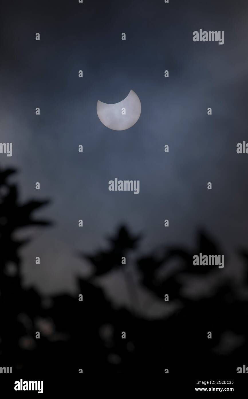 Flintshire, North Wales, UK Wednesday 10th June 2021, UK Weather:  A partial solar eclipse viewed between breaks in the clouds over the village of Lixwm in North Walles  © DGDImages/Alamy Live News Stock Photo