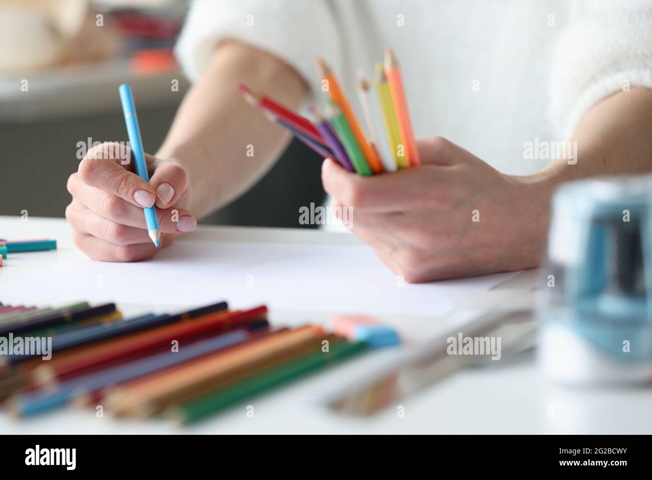 Women hands, multicolored pencils for creating sketches of fashionable