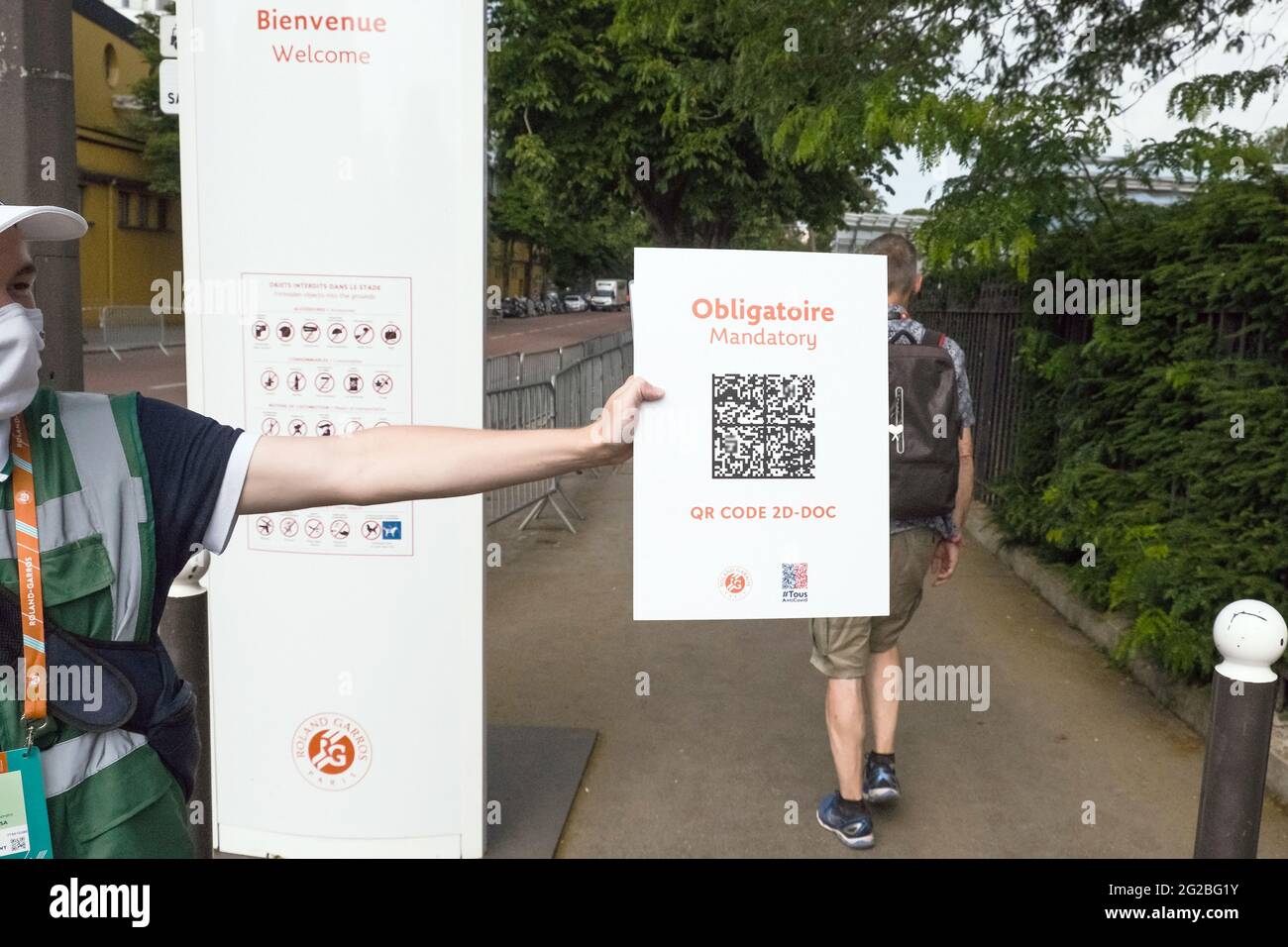 Paris, France. 10th June, 2021. Tennis: Grand Slam, French Open. An employee holds a sign at the entrance to remind spectators of a valid Corona test or vaccination. By means of a QR code, access to the tournament site is controlled in this way. Since the new Corona rules on June 9, 2021, more people are allowed back into the Stade Roland Garros. As the curfew in Paris now only starts at 11pm, 5000 spectators will also be allowed onto Centre Court. Credit: Frank Molter/dpa - ATTENTION: QR code has been made unreadable/dpa/Alamy Live News Stock Photo
