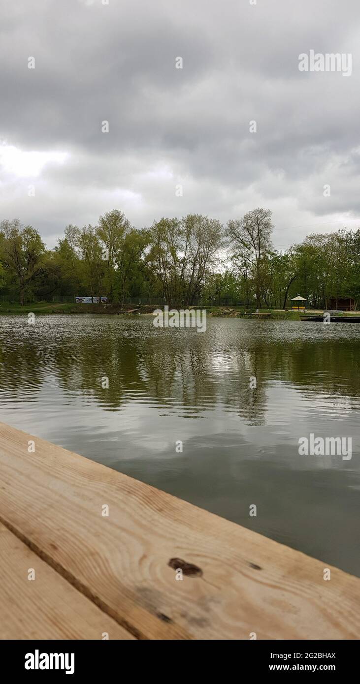 Reflection Natural Landscape View. Old wooden jetty, deck or pier in the lake. Nice looping background. Vertical photography Stock Photo