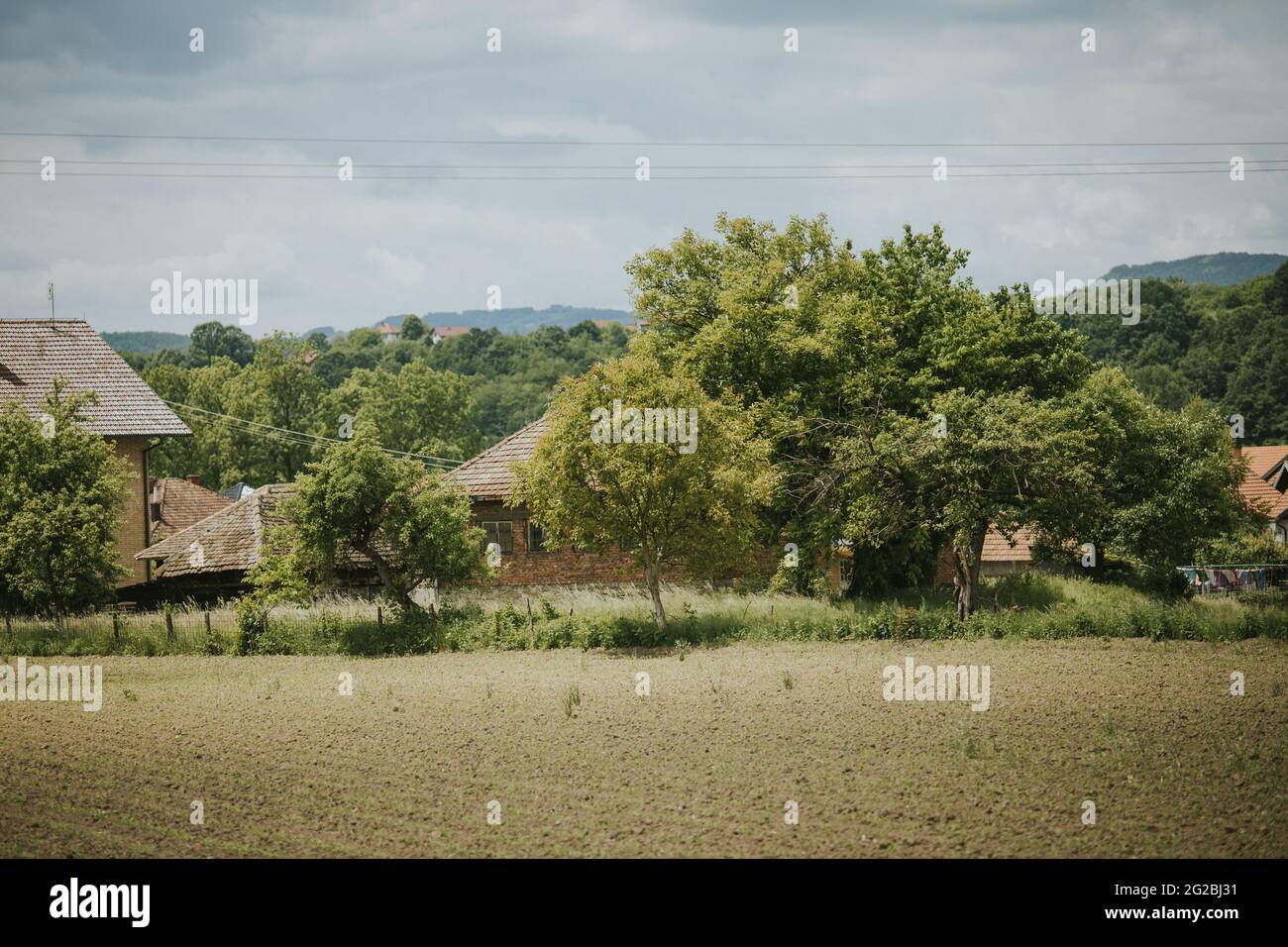 Agricultural field and rural houses on a cloudy day Stock Photo - Alamy