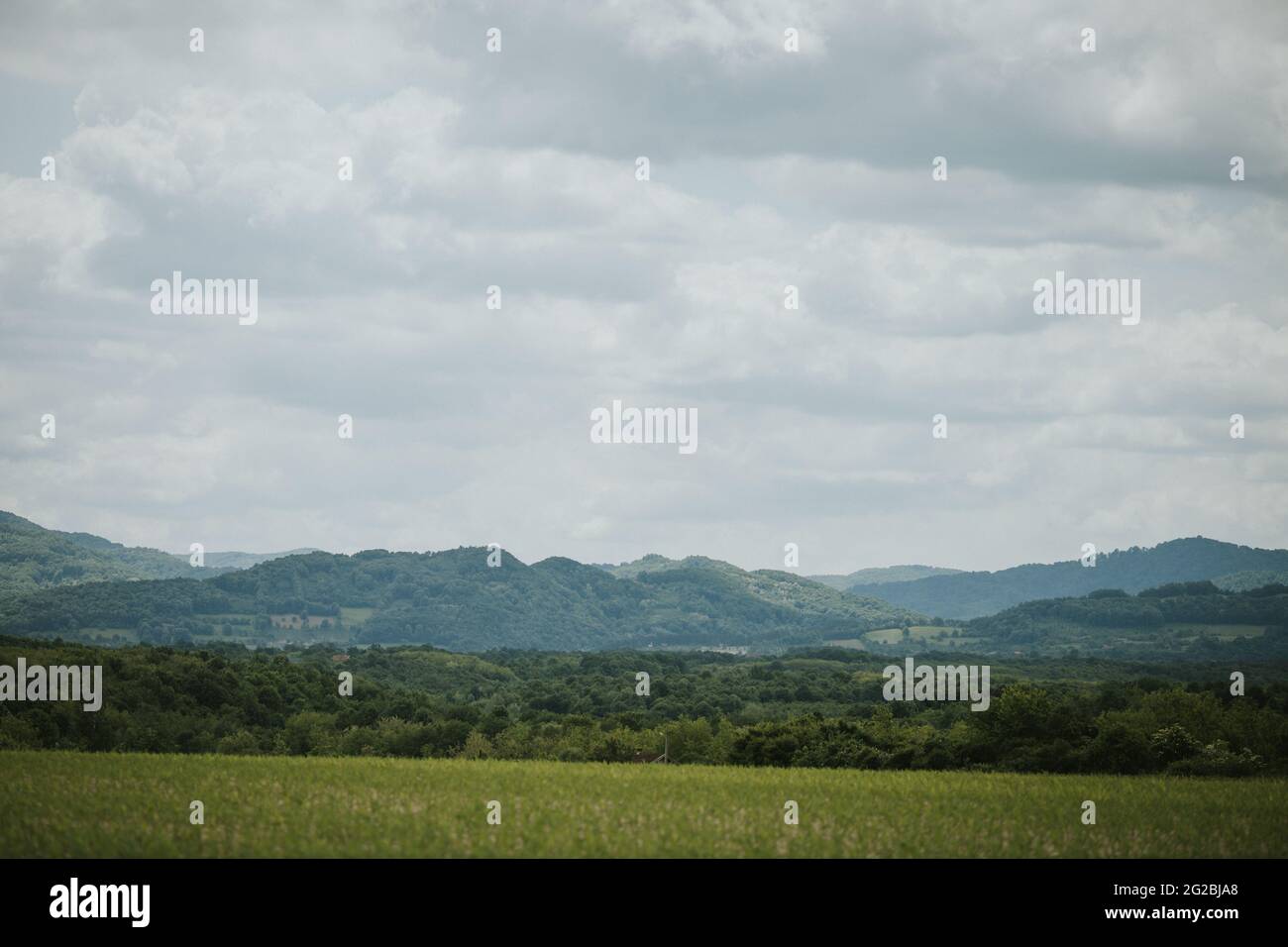 Agricultural field surrounded by hills on a cloudy day Stock Photo - Alamy